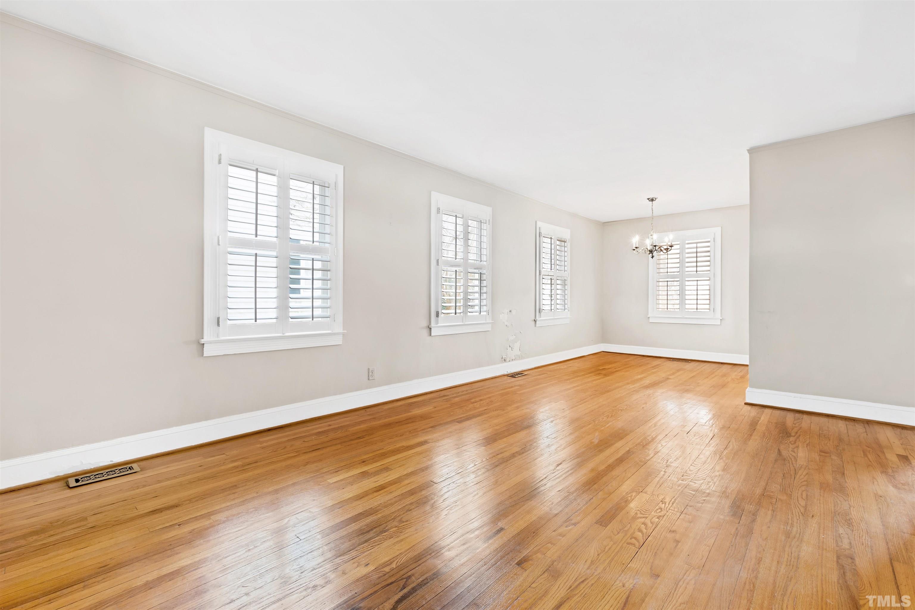 2713 Gordon Street Raleigh, NC 27608 - Photo 5 of 35 an empty room with wooden floor and windows