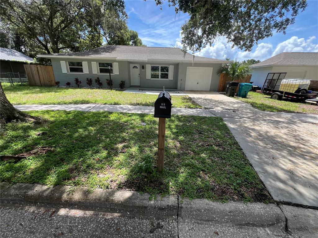 a front view of a house with a yard and trees