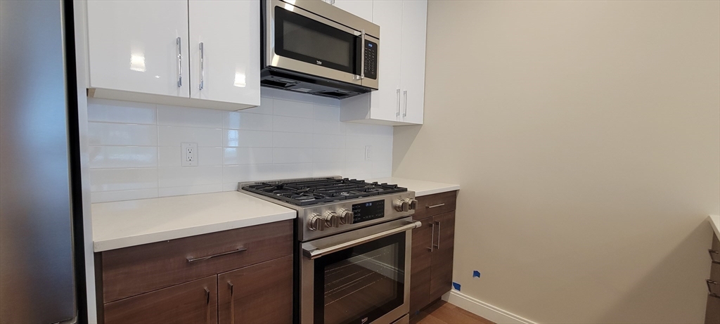 425 Lagrange Street, Unit 206 Boston, MA 02132 - Photo 7 of 15 a kitchen with stainless steel appliances a stove and a microwave