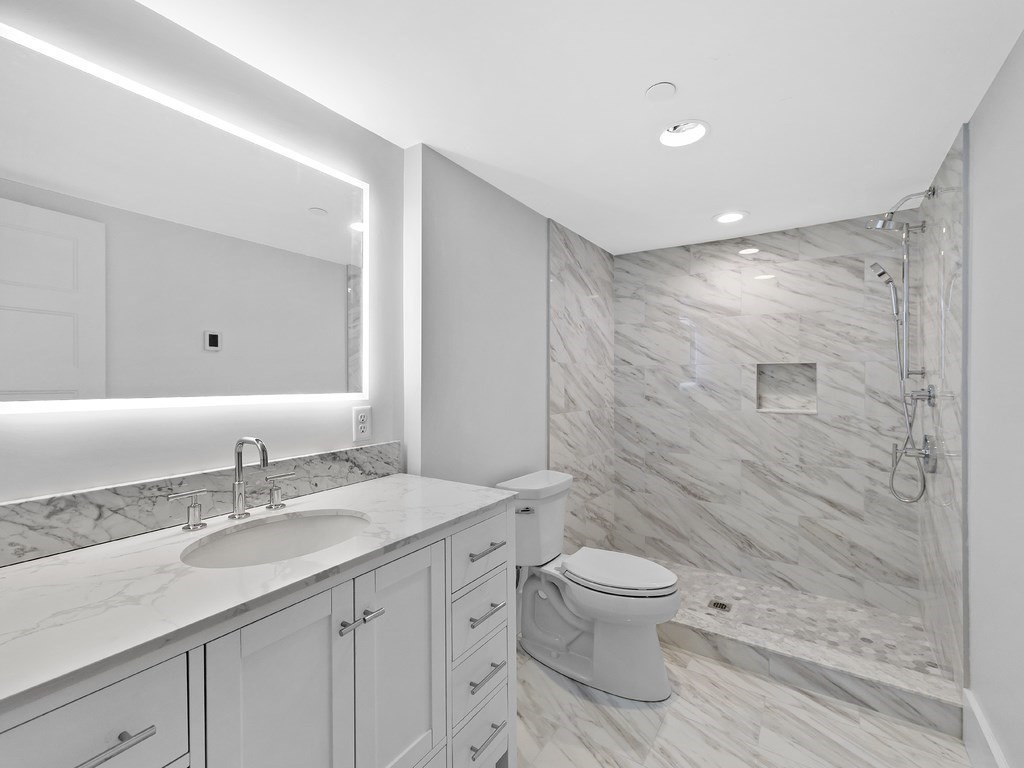 9 Monument Square, Unit 1 Boston, MA 02129 - Photo 11 of 15 a bathroom with a granite countertop sink a toilet and shower