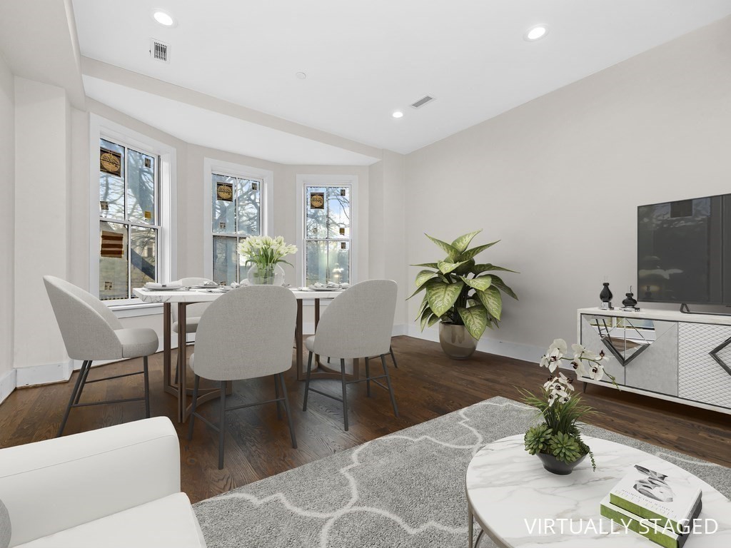9 Monument Square, Unit 1 Boston, MA 02129 - Photo 2 of 15 a living room with furniture a flat screen tv and a potted plant