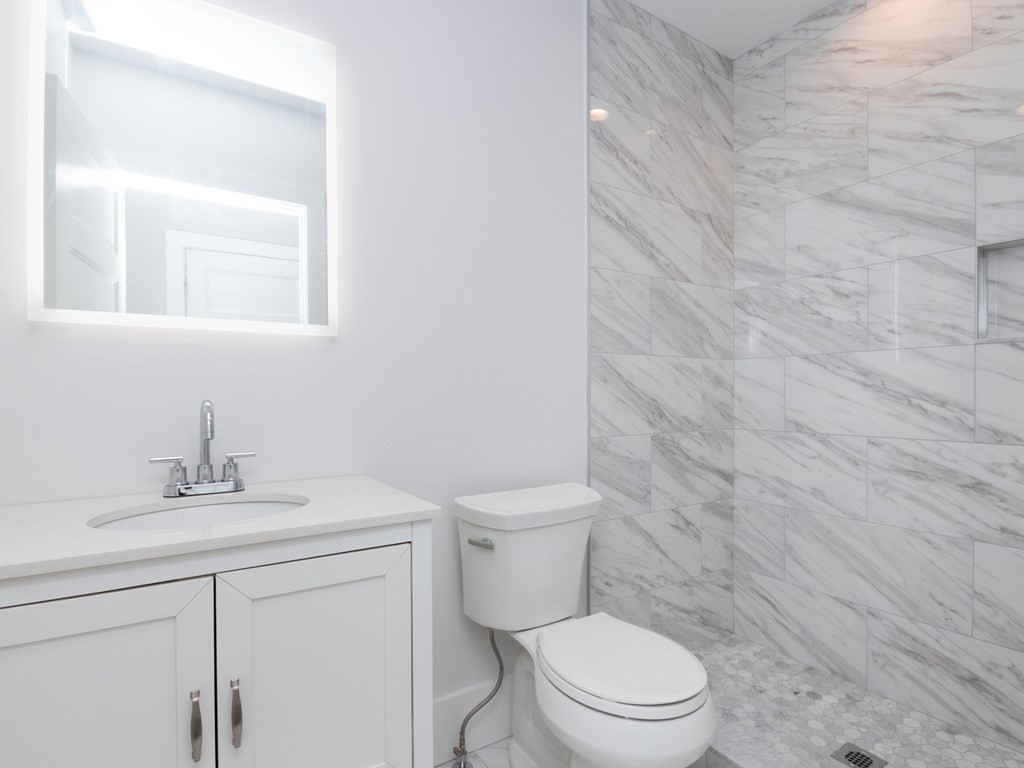 9 Monument Square, Unit 1 Boston, MA 02129 - Photo 8 of 15 a bathroom with a toilet sink vanity and mirror
