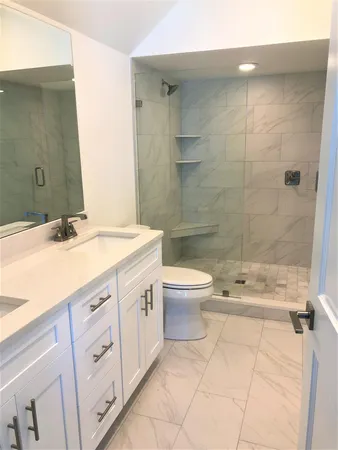 a bathroom with a sink a toilet and shower