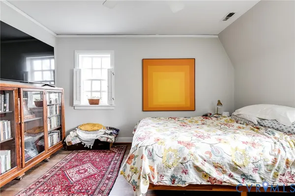 a bedroom with a bed and wooden floor