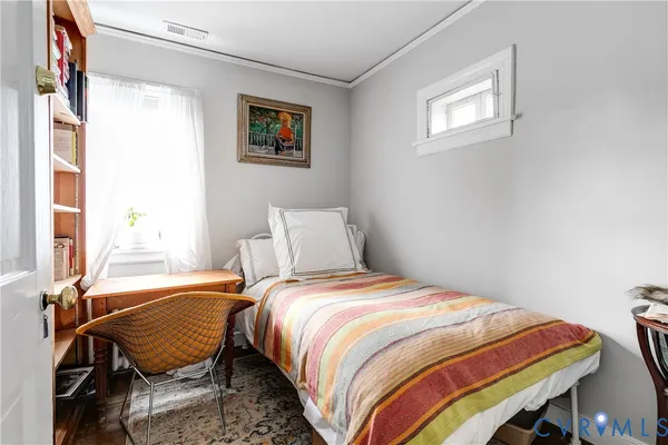 a bedroom with a bed a window and chair