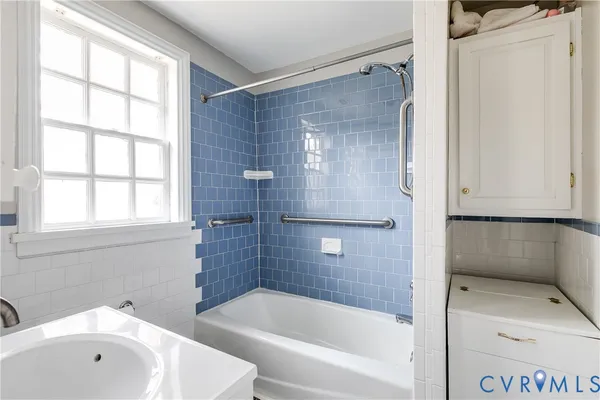 a bathroom with a tub shower and sink