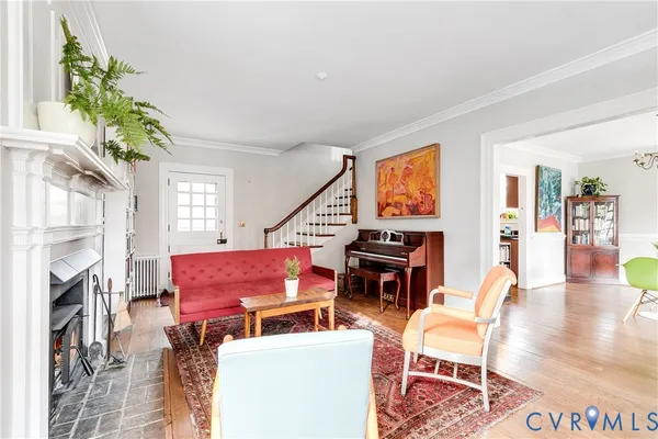 a living room with furniture a fireplace and wooden floor