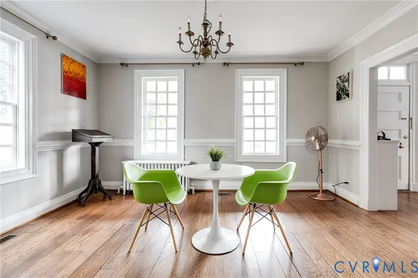 a dining room with furniture and a wooden floor