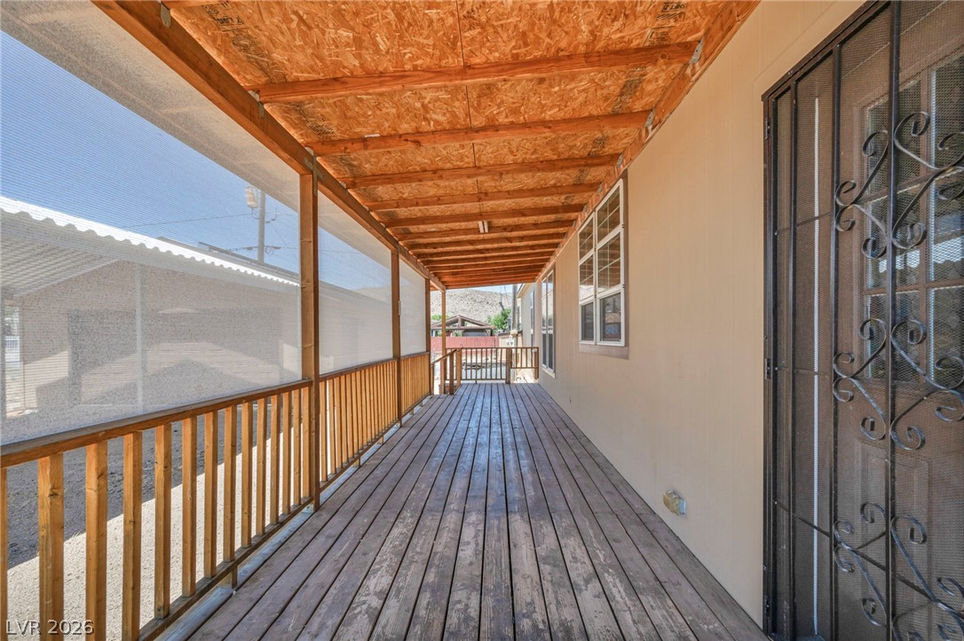 225 California Street Searchlight, NV 89046 - Photo 26 of 64 An inviting covered porch extends the home's living space with a wooden deck and protective screens.