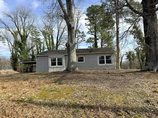 a view of a yard in front of a house with large trees