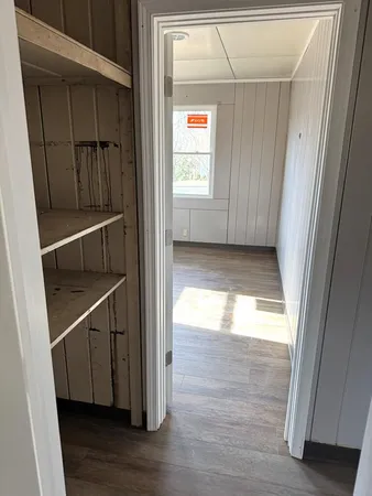 a view of an empty room with wooden floor