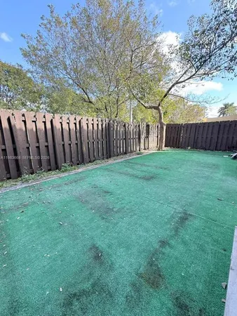 a view of a yard with wooden fence