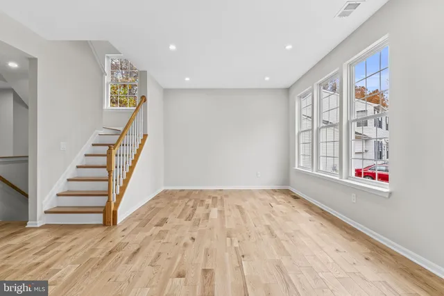 a view of an empty room with wooden floor and entryway