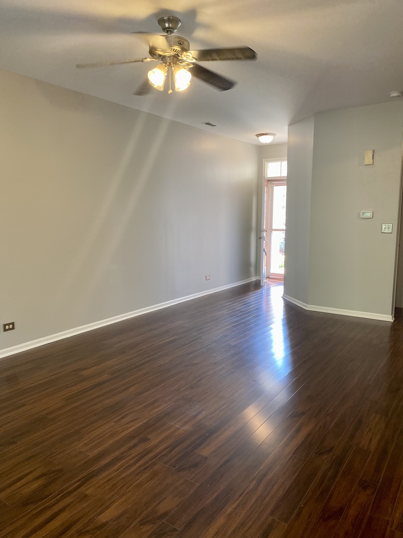 2402 Georgetown Circle Aurora, IL 60503 - Photo 2 of 10 a view of an empty room with wooden floor and a ceiling fan