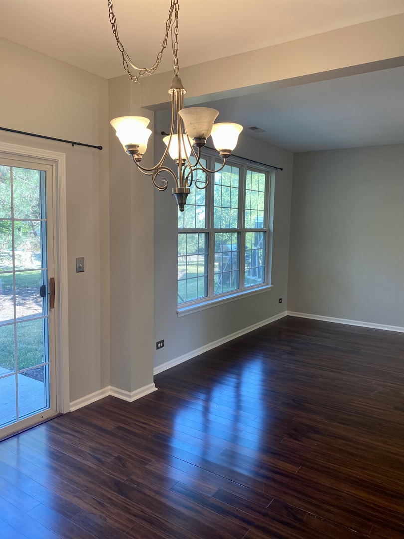 2402 Georgetown Circle Aurora, IL 60503 - Photo 3 of 10 a view of an empty room with wooden floor and a window