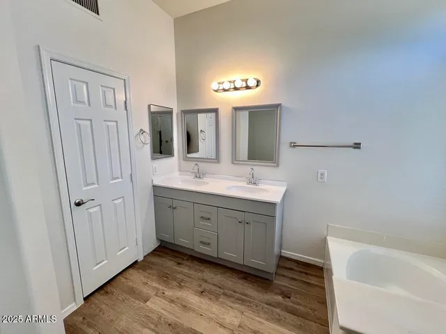 a spacious bathroom with a bathtub sink and mirror