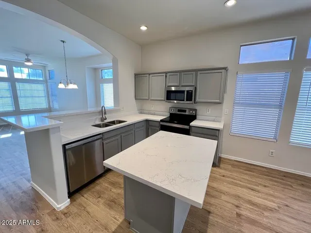 a kitchen with stainless steel appliances a microwave a stove a sink and a refrigerator