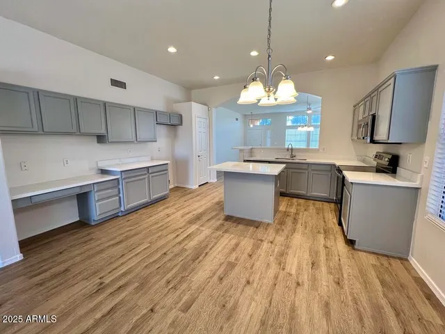 a large kitchen with cabinets a sink and a wooden floor
