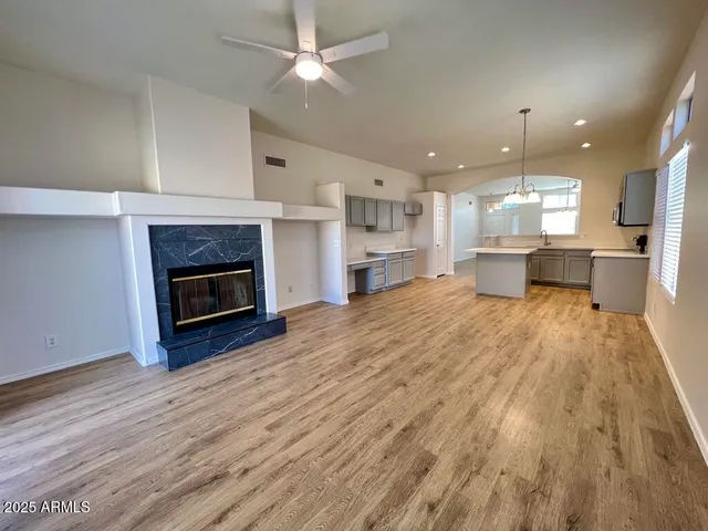 a open kitchen view with a stove fireplace and wooden floor