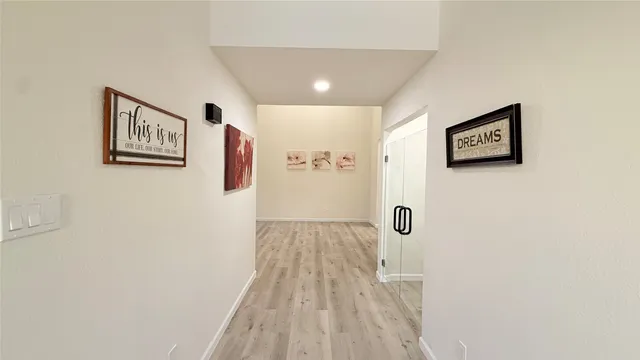 a view of a livingroom with a fireplace a ceiling fan and wooden floor