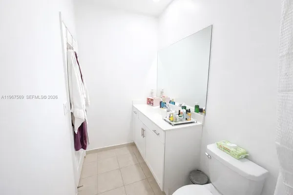 a bathroom with a sink a toilet and shower curtain