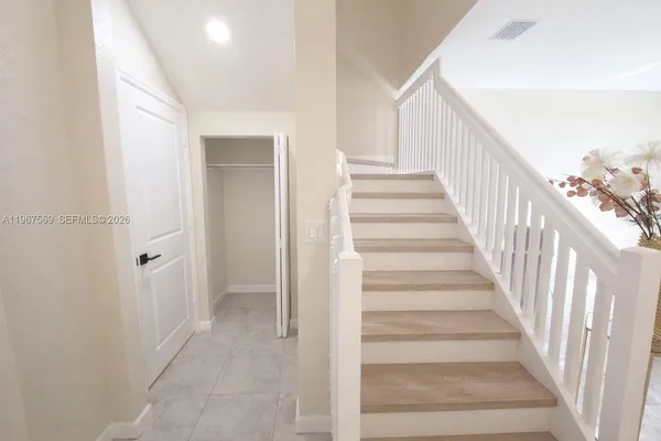 a view of staircase with wooden floor and white walls