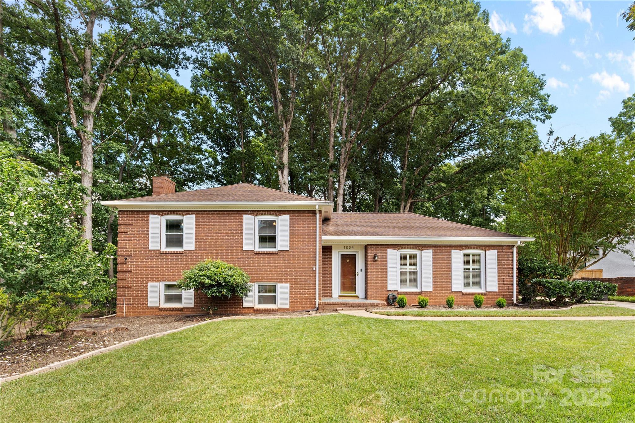 a front view of a house with a garden