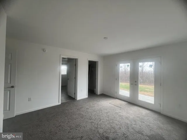 an empty room with windows and closet