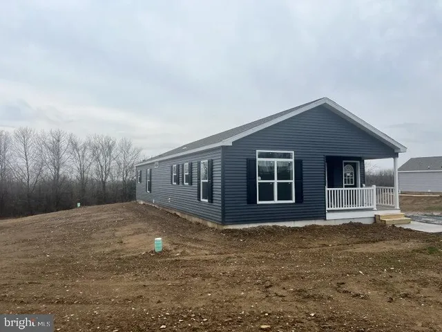 a front view of house with yard and trees in the background