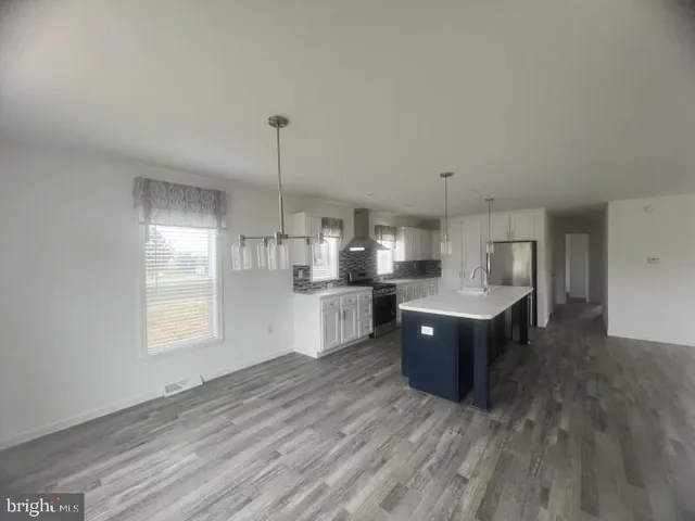 a kitchen with kitchen island cabinets wooden floor and window