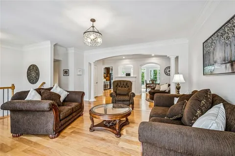 a kitchen with stainless steel appliances granite countertop a sink a counter space and living room view