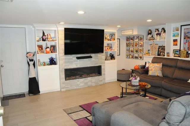 a living room with furniture a flat screen tv and a fireplace