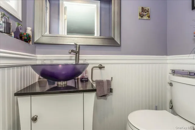 a bathroom with a toilet a sink and a mirror