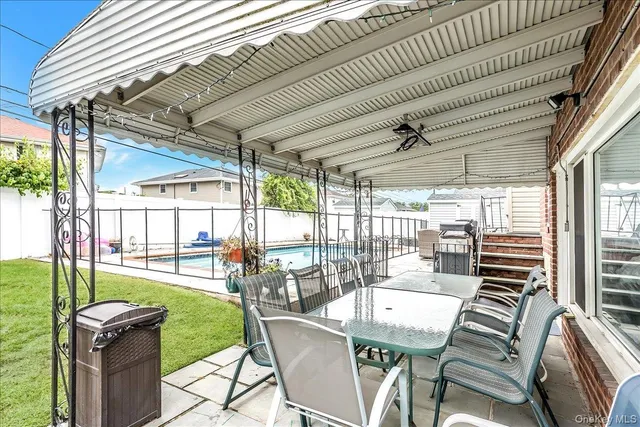a view of a patio with a table chairs and a backyard
