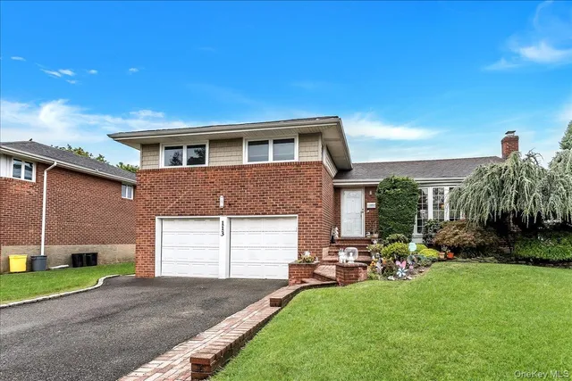 a front view of a house with a garden and yard