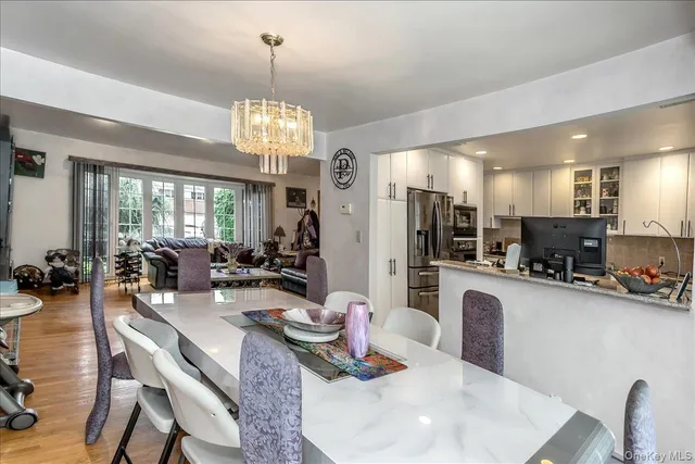 a very nice looking dining room with furniture a chandelier and wooden floor