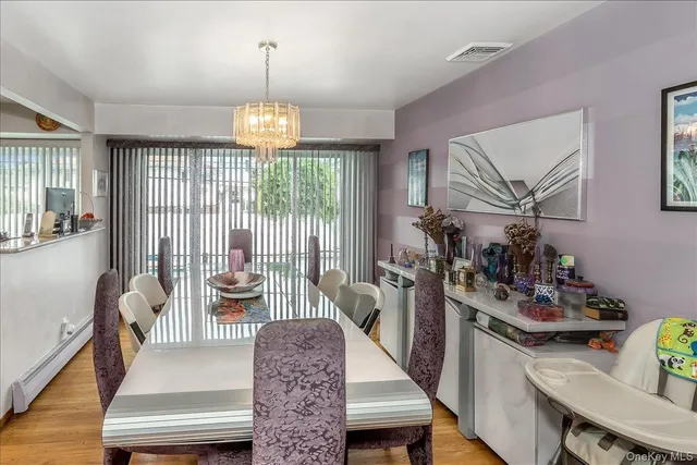 a view of a dining room with furniture a chandelier and wooden floor