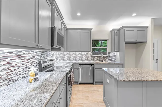 a kitchen with stainless steel appliances granite countertop a sink stove and refrigerator