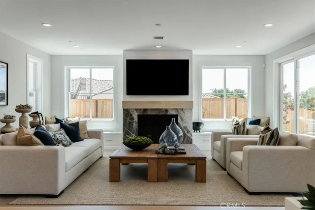a living room with furniture a fireplace and a flat screen tv