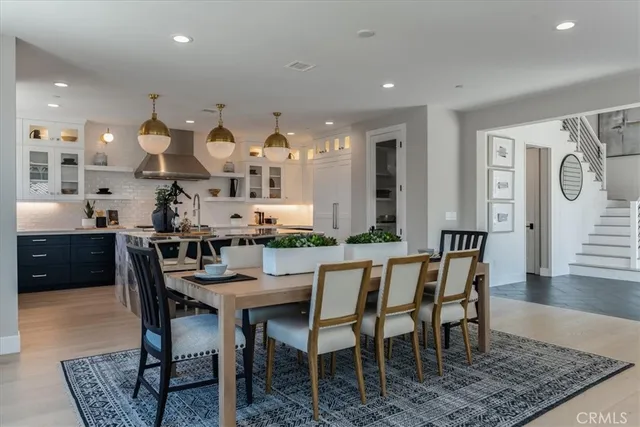 a dining hall with stainless steel appliances a dining table and chairs