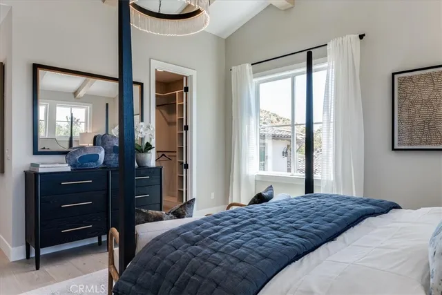 a bedroom with a bed and a mirror on dresser