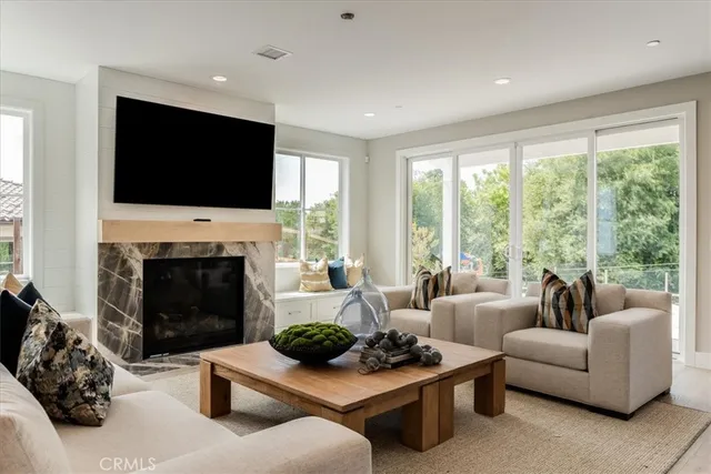 a living room with furniture a flat screen tv and a fireplace
