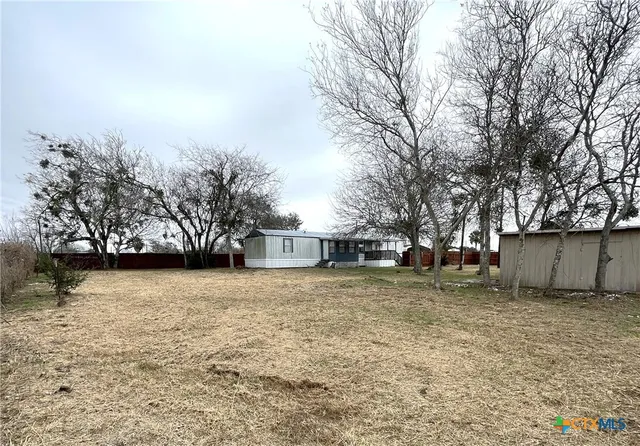 a backyard of a house with plants and trees