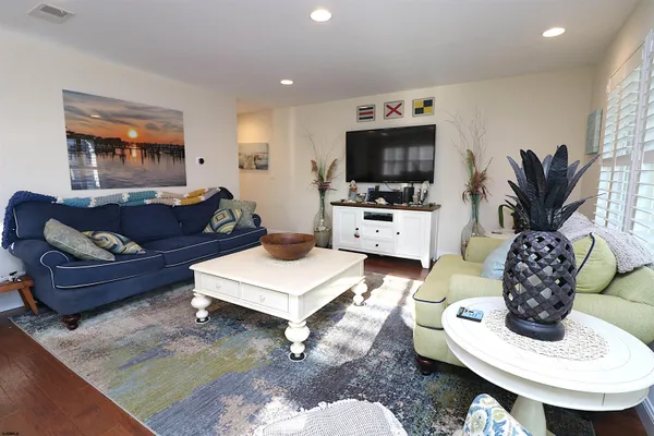 a living room with furniture a flat screen tv and a dining table