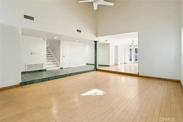 a view of a room with a wooden floor and a chandelier