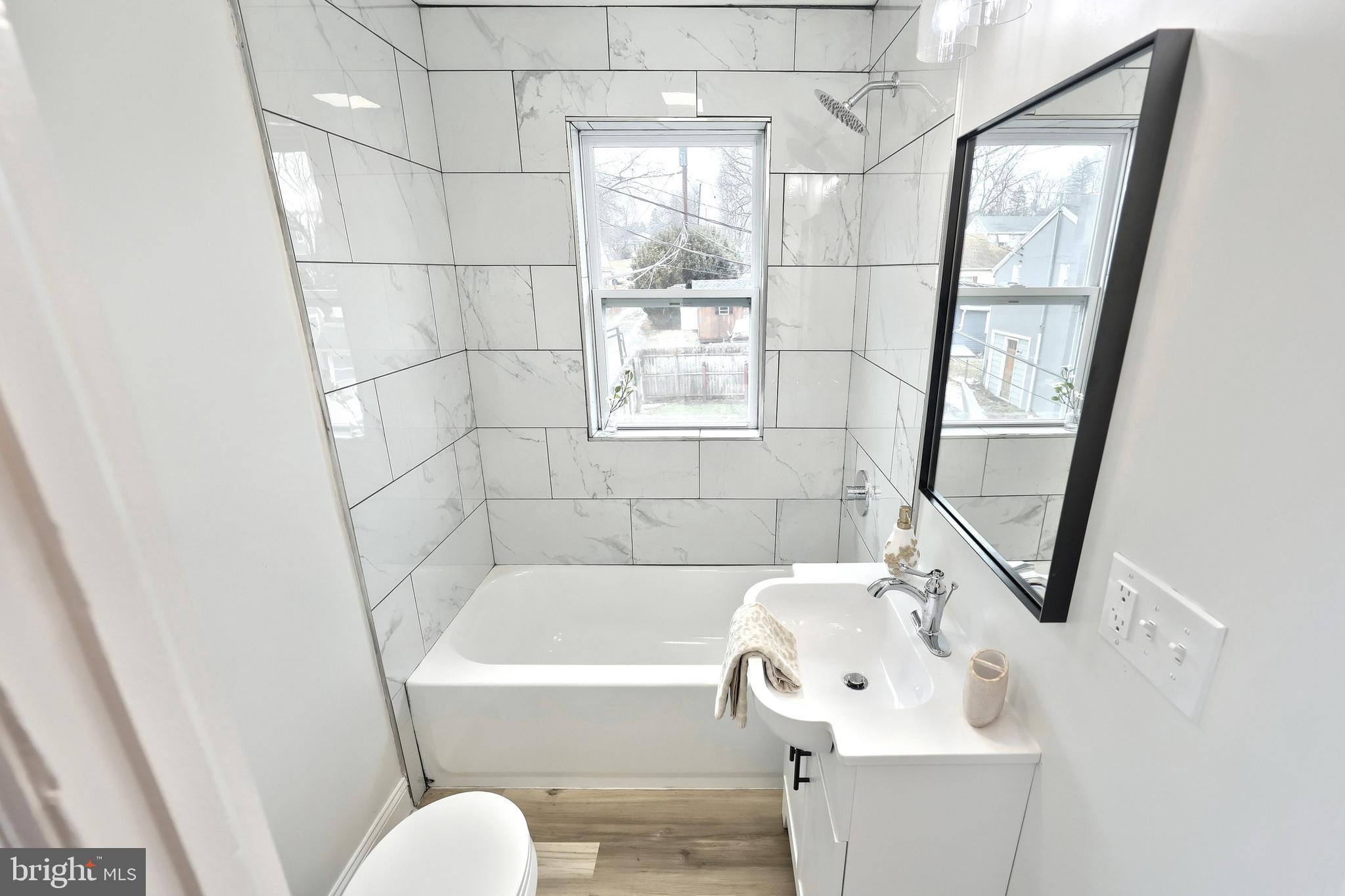 1611 Meade Street Reading, PA 19607 - Photo 27 of 59 a bathroom with a bathtub a sink and a window