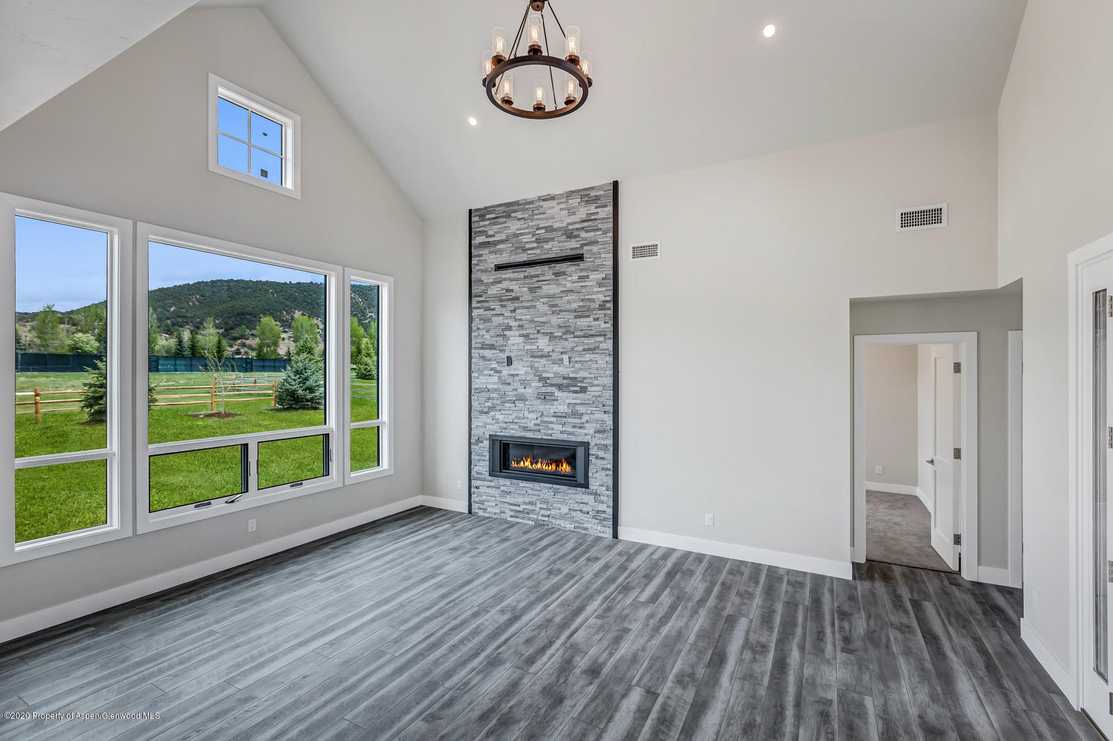 347 Equestrian Way Carbondale, CO 81623 - Photo 3 of 31 a view of an empty room with wooden floor fireplace and a window