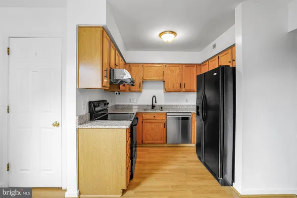 a kitchen with a refrigerator a stove top oven and a sink