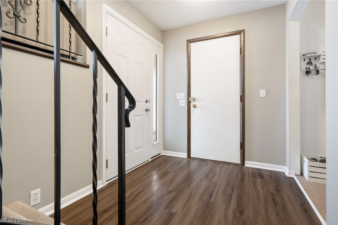 801 Netherwood Avenue Northwest Canton, OH 44708 - Photo 6 of 44 Entrance foyer with dark lvt wood-style flooring, and a textured ceiling, access door to garage