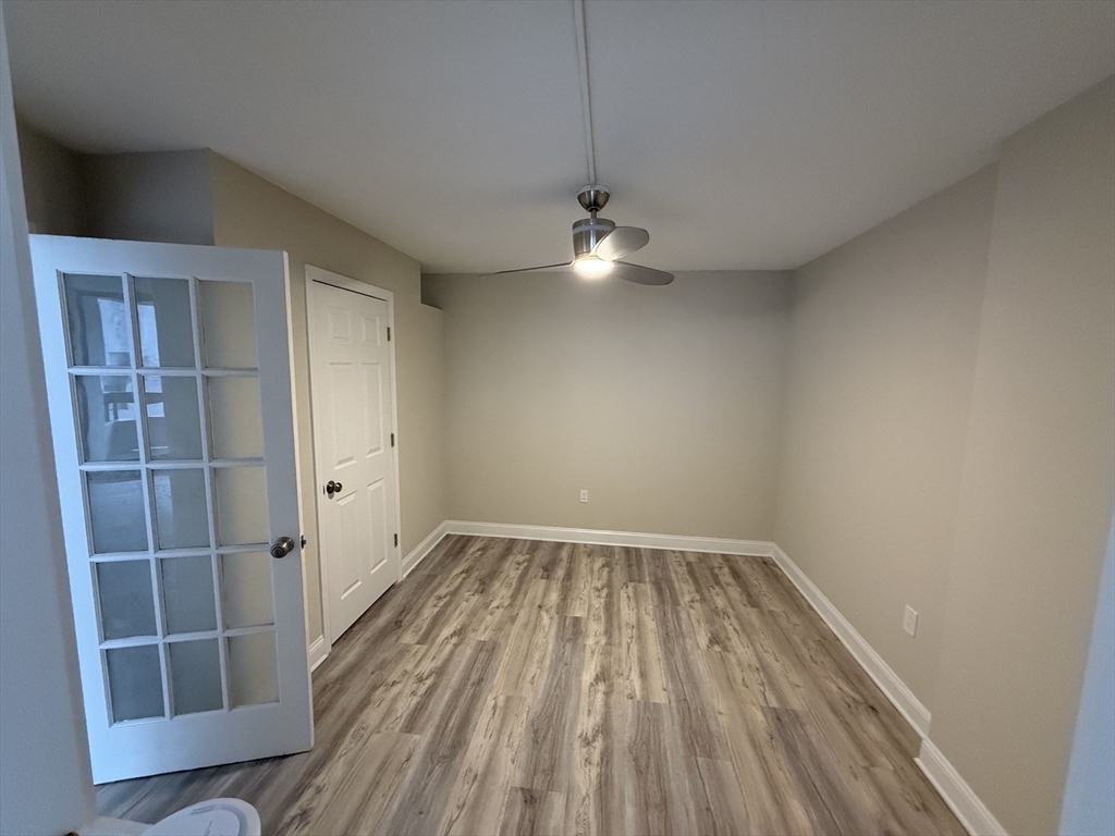 566 Commonwealth Avenue, Unit 308 Boston, MA 02215 - Photo 7 of 14 wooden floor in an empty room with a window